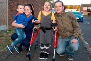 girl using reverse walker and family